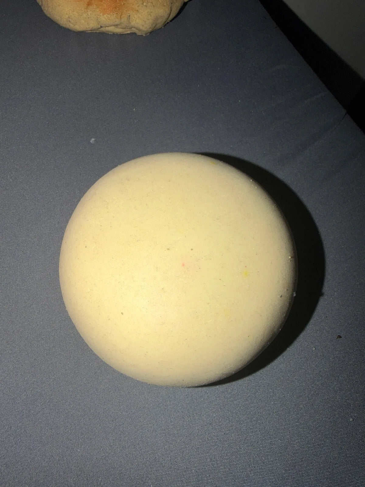 Cream Milk bun squishy from above on a gray surface