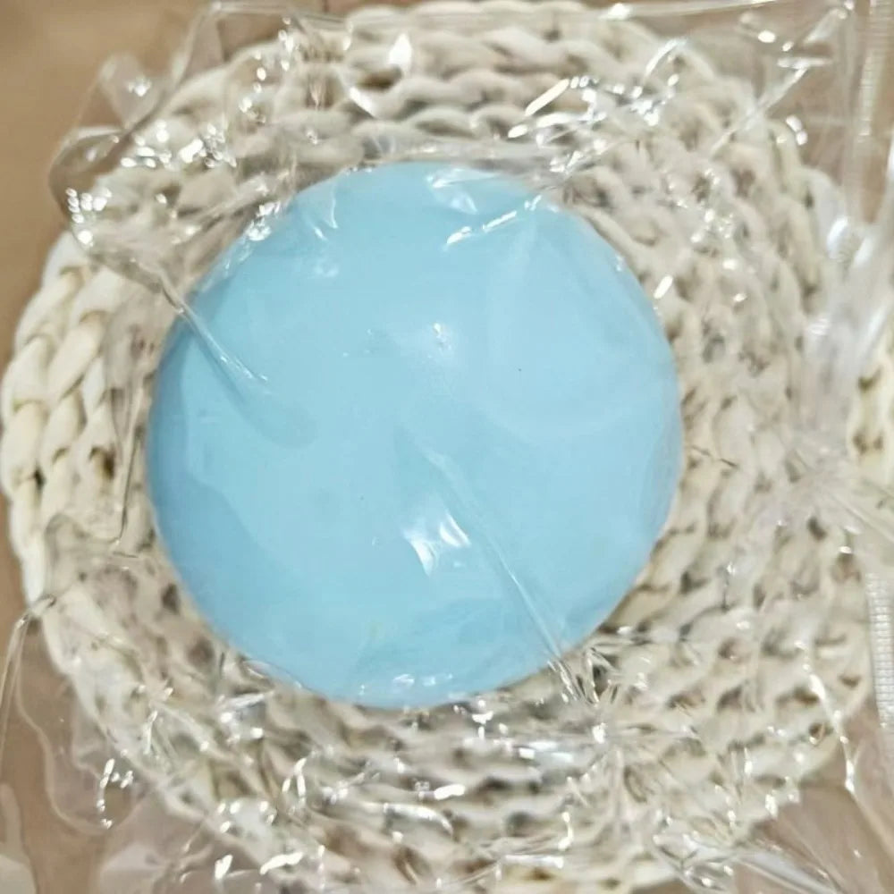 Blue gooey stress ball, about 10 cm, in a clear bag on a woven mat