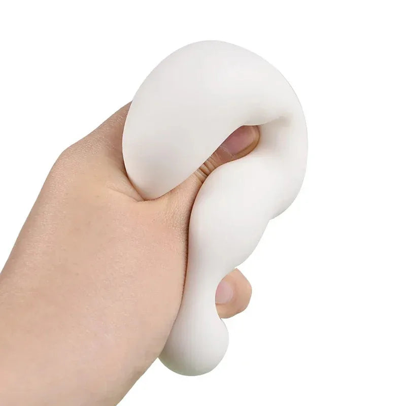 White tofu cube squishy being squeezed in a hand on a white background