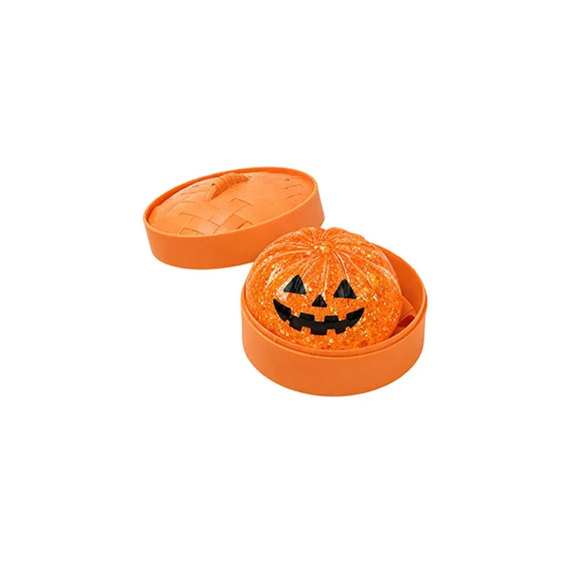 Orange jack-o'-lantern ghost bun squishy in an orange steamer with the lid off