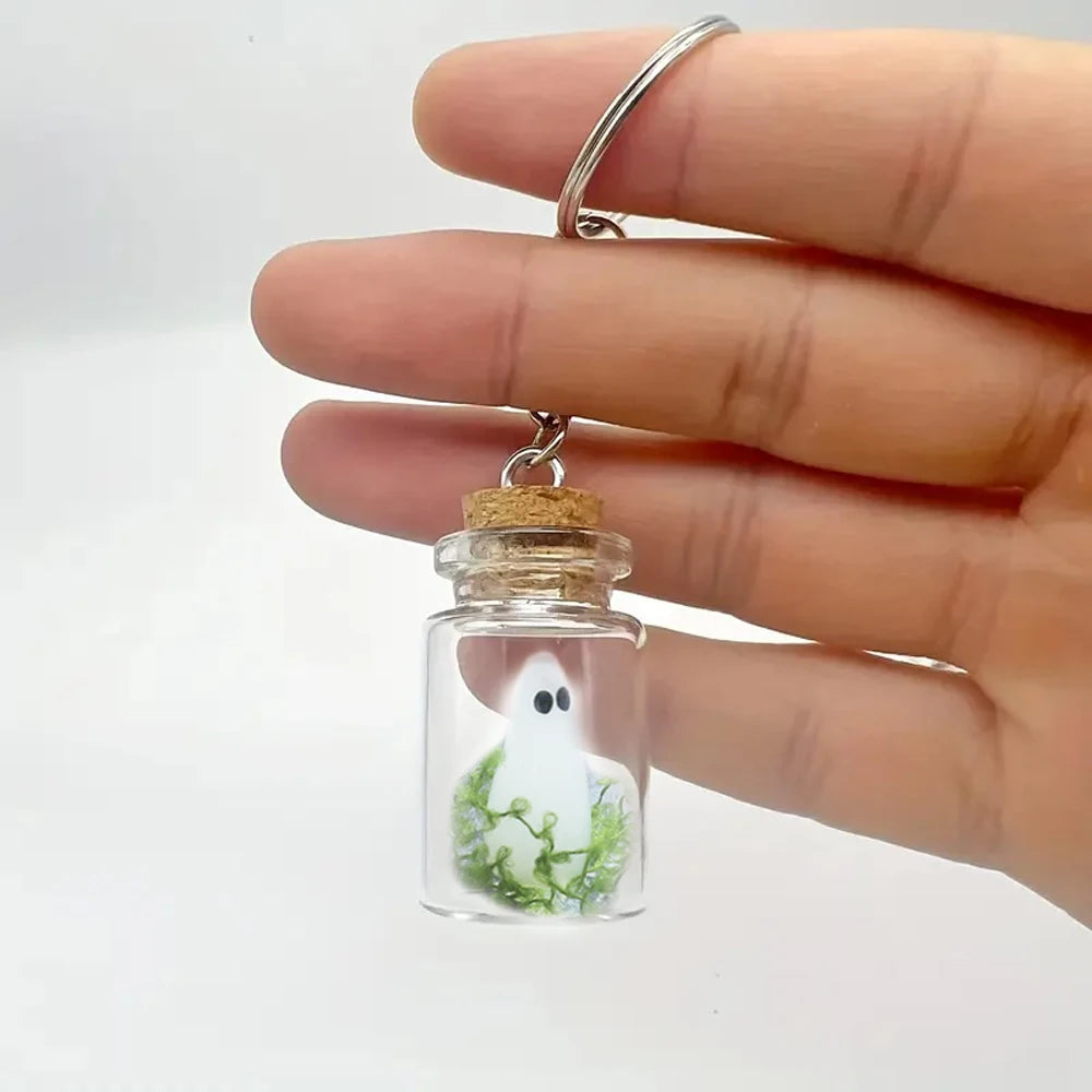 Ghost bottle keychain with a cork top held in a hand in daylight