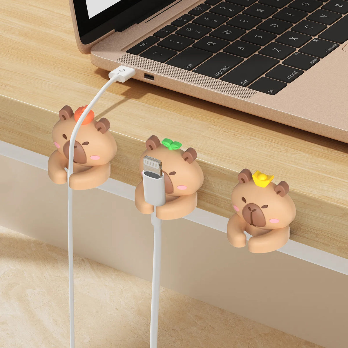 Capybara cable clips holding charging cables on a desk edge; a capybara design is shown among other capybara styles