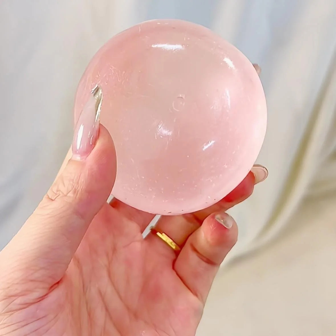 Clear pink squishy ball resting in an open hand