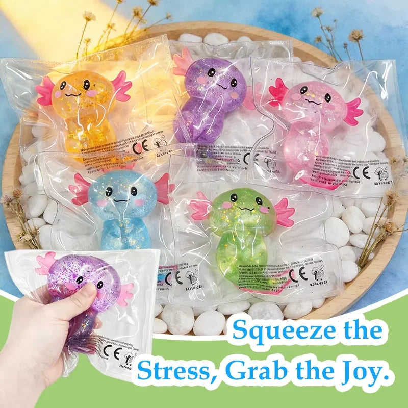 Glitter axolotl squishies in assorted colors on a tray, one being squeezed in a hand