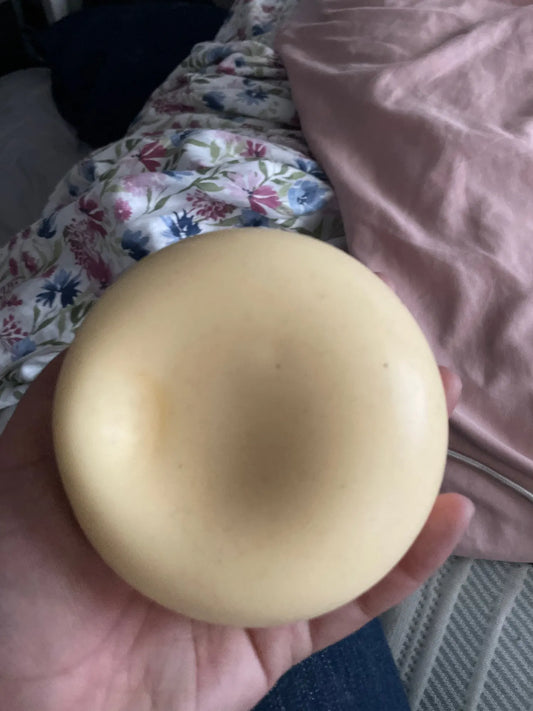 Cream Milk bun squishy held in an open hand