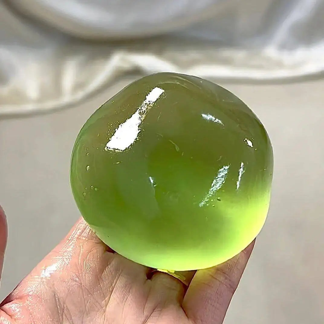 Lime translucent jelly squeeze ball, about 6 cm, held in a hand
