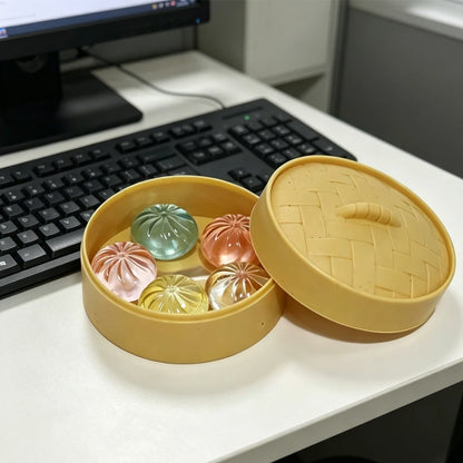 Mini dumpling squishies in a steamer basket on a desk