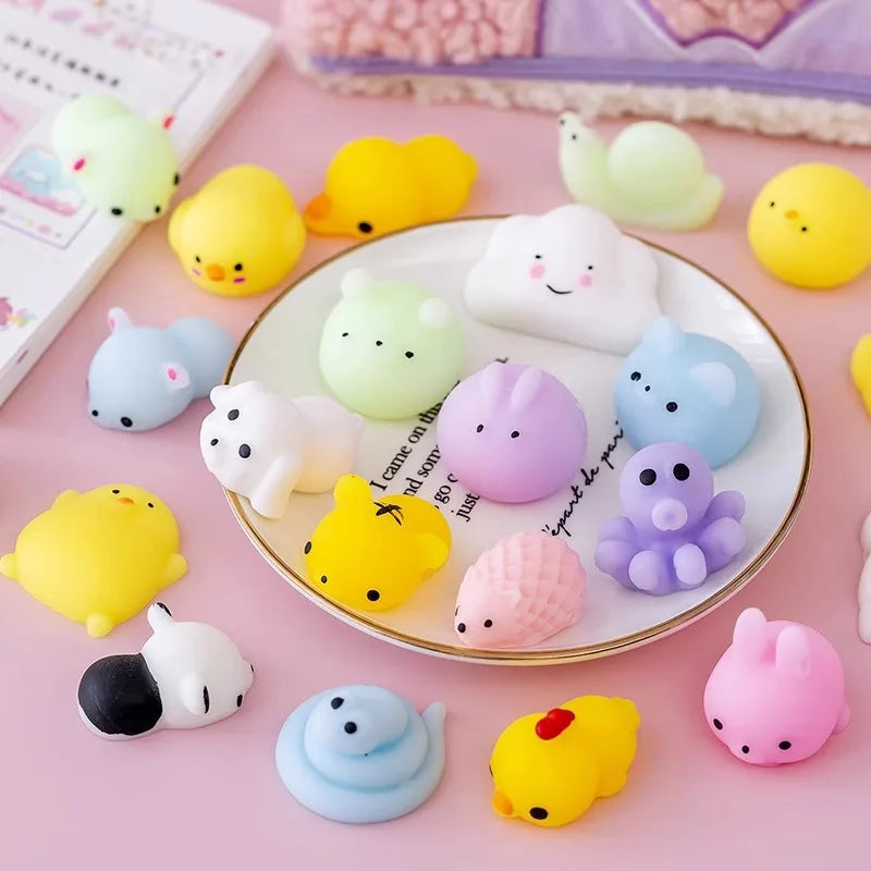Mini mochi animal squishies on a plate and desk in pastel colors