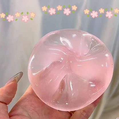 Clear pink squishy ball pressed in at the top, held in one hand