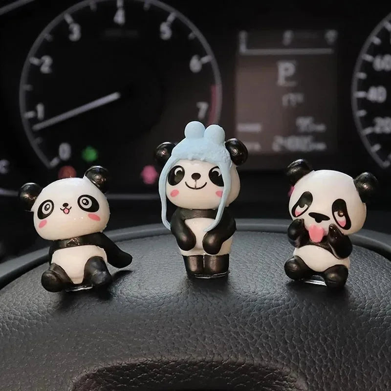 Three panda figures up close, including one wearing a blue hat
