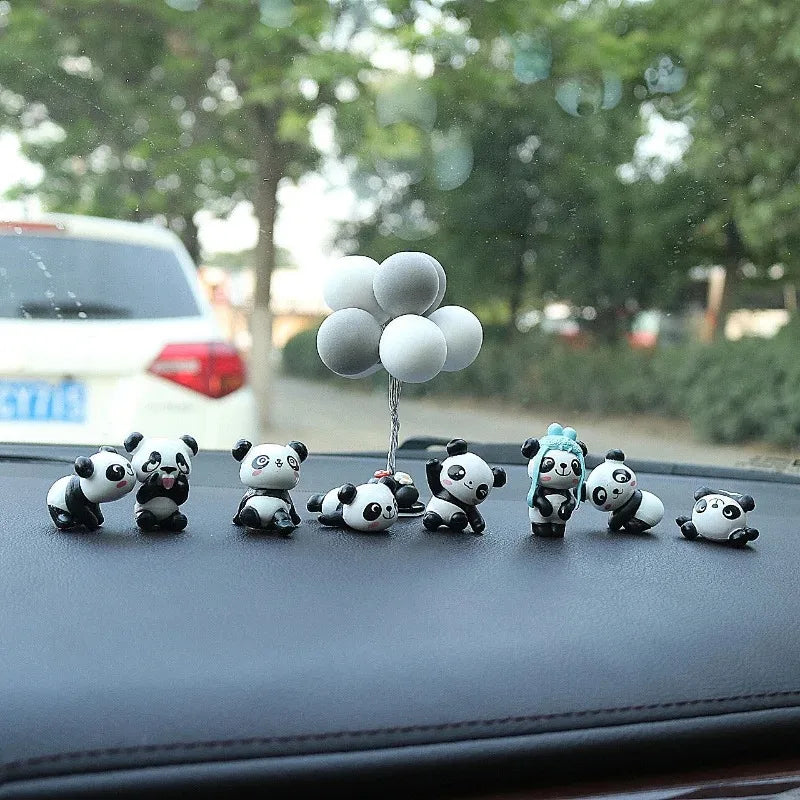 All 8 little panda figures lined up on a dashboard