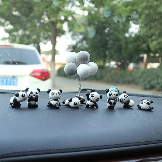 All 8 little panda figures lined up on a dashboard