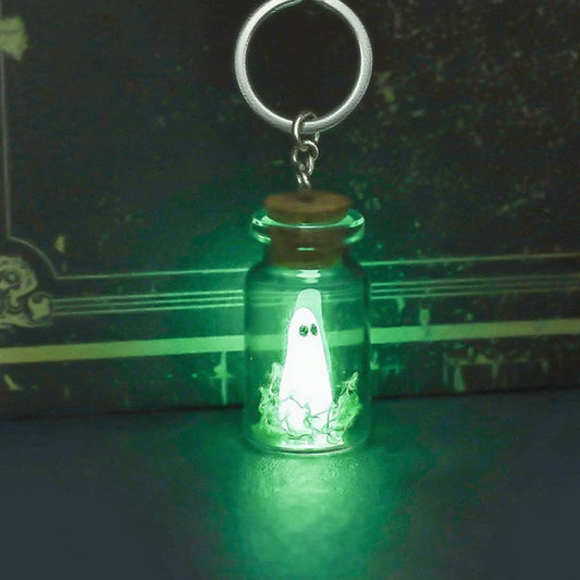 Ghost bottle keychain glowing green in the dark