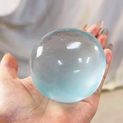 Blue translucent jelly squeeze ball, about 6 cm, resting in a palm