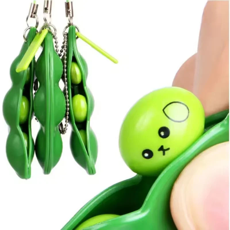 Hand squeezing the edamame pop squishy keychain so a bean pops out