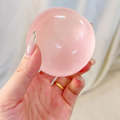 Clear pink squishy ball resting in an open hand