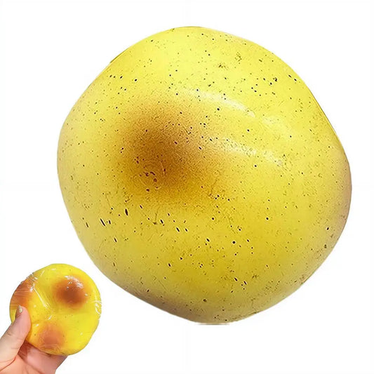 Yellow potato pudding squishy with toasty brown spots, shown large and in a hand