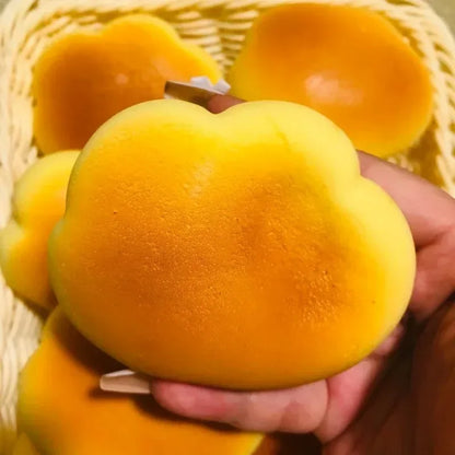 Caramel cloud bread squishy held in one hand, more cloud bread squishies behind it