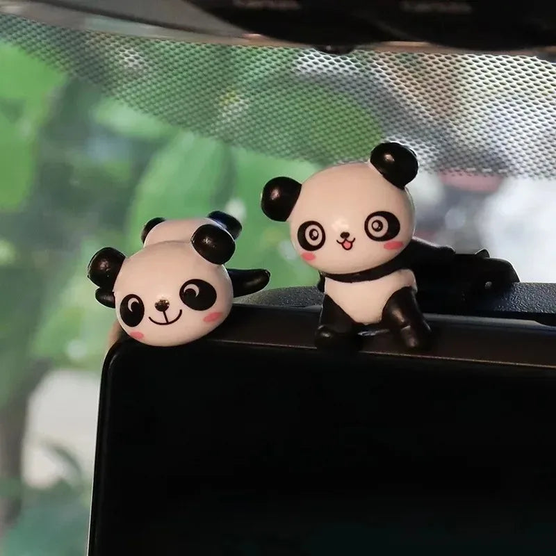 Two panda figures perched on the edge of a screen