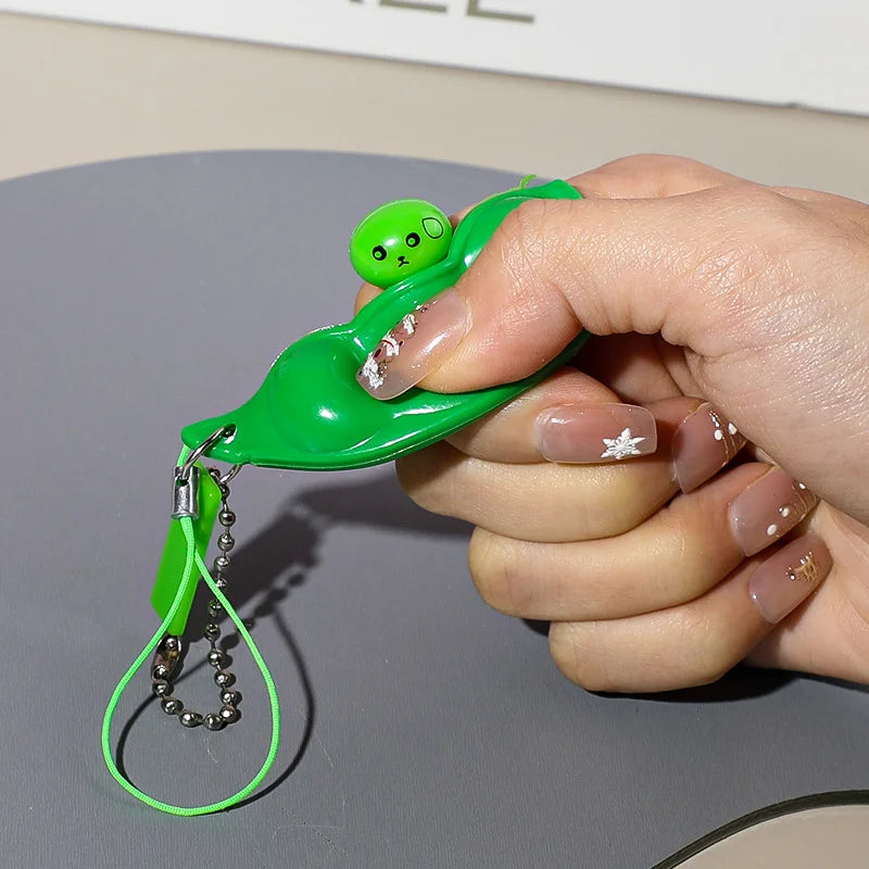 Edamame pod squishy keychains with a smiling bean popping out