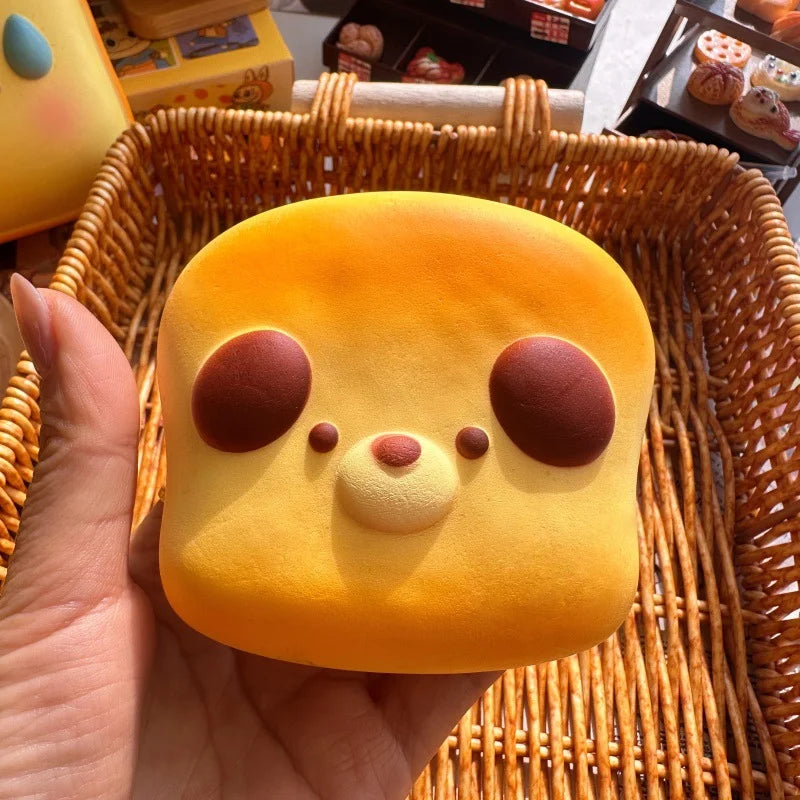 Hand holding a toast-shaped animal bread bun squishy with round ears