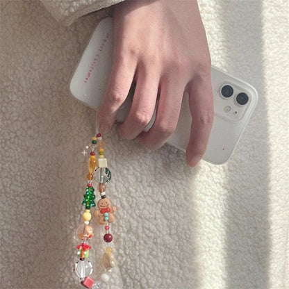 Gingerbread and Christmas tree beaded strap hanging from a white phone