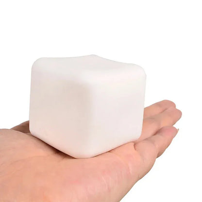 White tofu cube squishy resting on an open palm