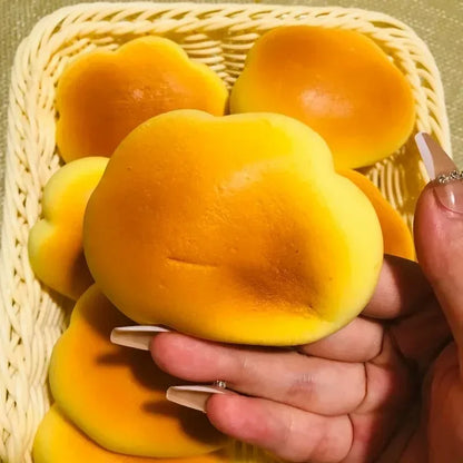 Caramel cloud bread squishy held up over a basket of more cloud bread squishies