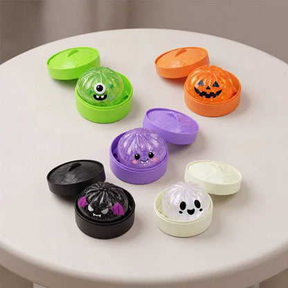 Ghost bun squishies with lidded steamers in Halloween colors on a table