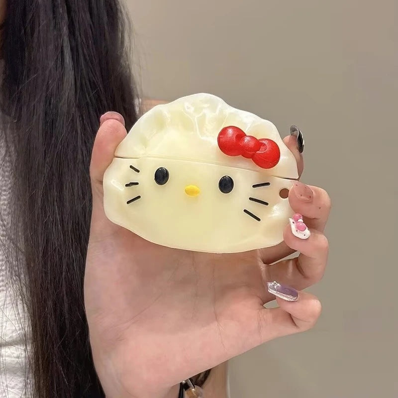 Cream 3D dumpling earbud case with a cat face and red bow, held in a hand