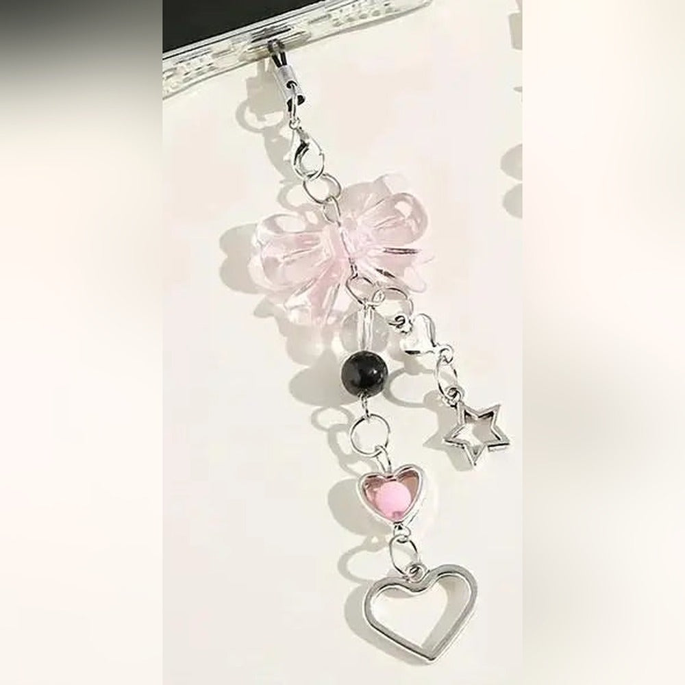 Pink bow beaded phone charm strap clipped to a phone, with heart and star charms